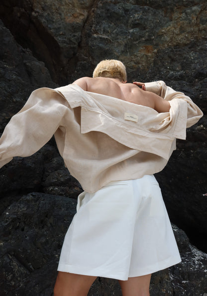 Person wearing a Francesco Tan Shirt and Lewis White Shorts on a dark stone surface